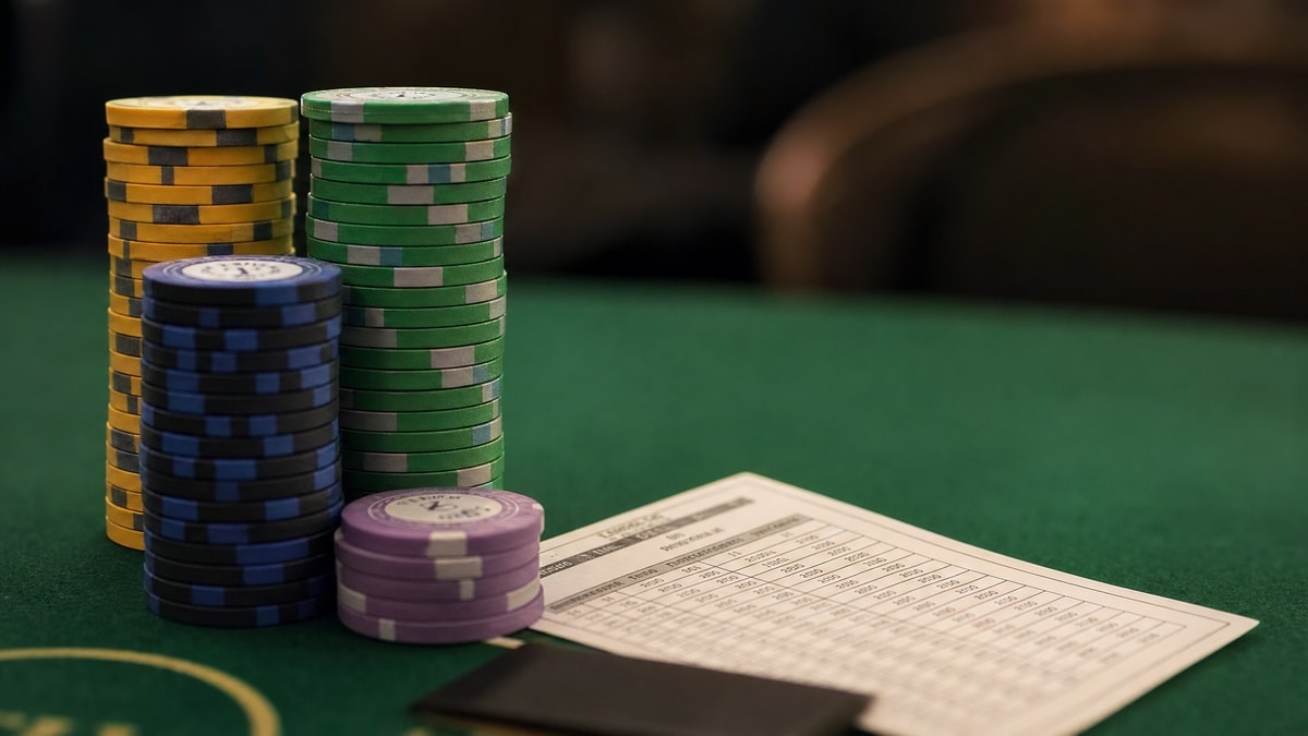 Tournament chips and a schedule card on a poker table at a live series