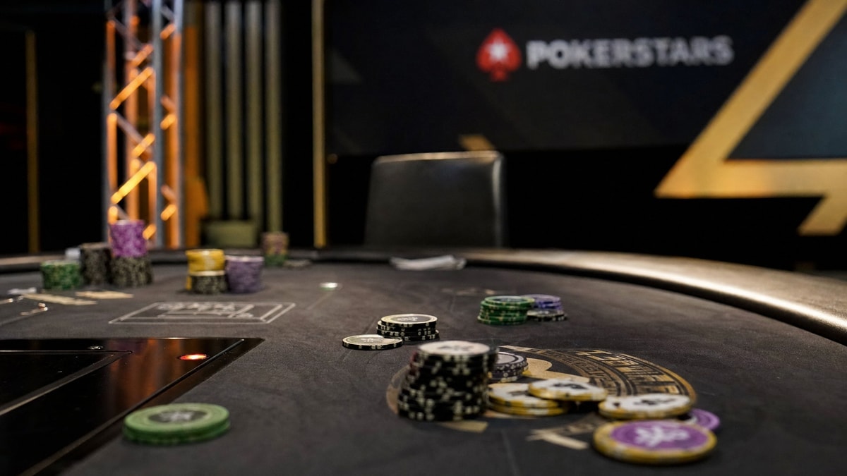 A high-stakes poker table with an operator banner blurred in the background