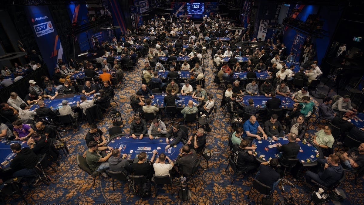 Crowded poker tournament room with multiple tables